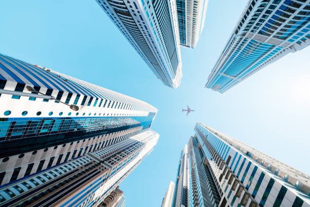 Skyscrapers in Dubai with an airplane overhead, illustrating international trade and tariff regulations.