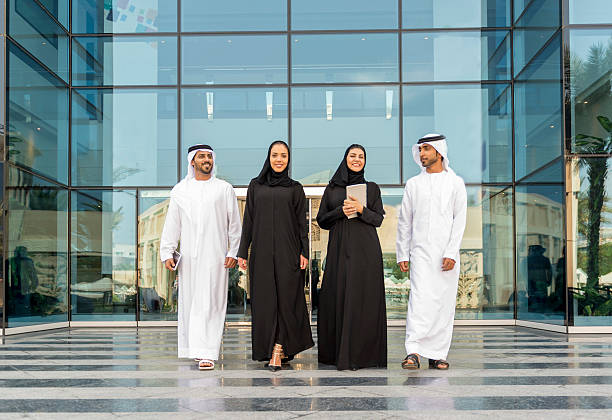 Business professionals walking confidently outside a modern office building in KIZAD Free Zone, UAE.